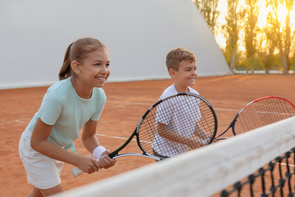 Happy,children,playing,tennis,on,court,outdoors