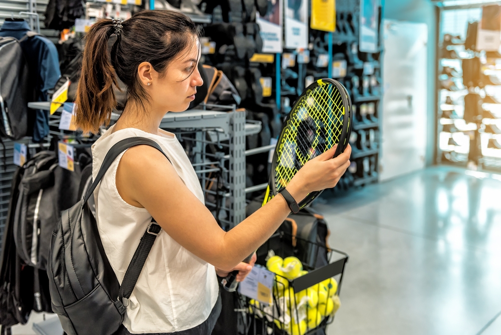 Young,sporty,woman,chooses,a,tennis,racket,in,a,sport