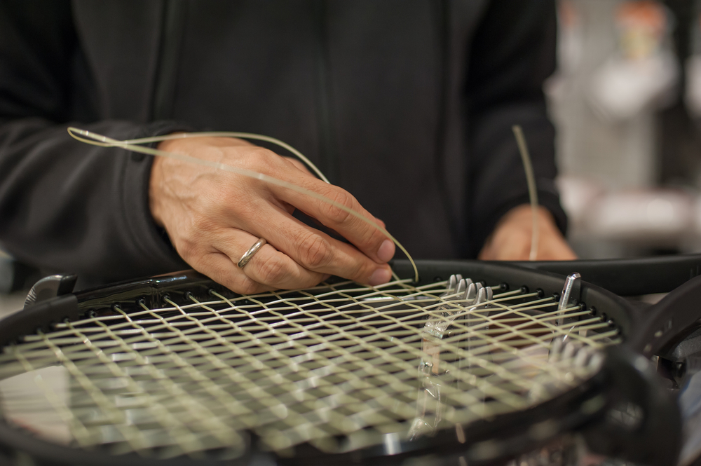 Stringing,machine.,close,up,of,tennis,stringer,hands,doing,racket